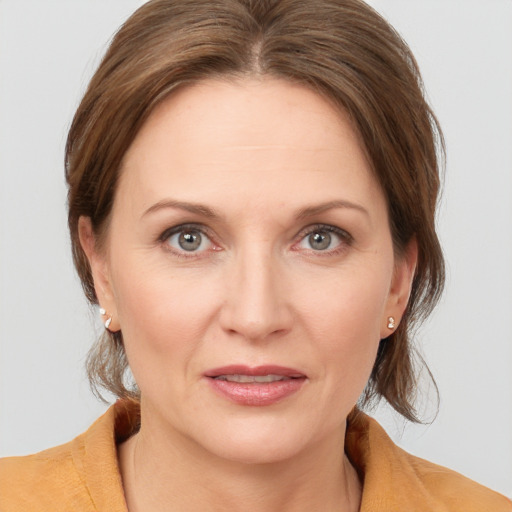 Joyful white adult female with medium  brown hair and grey eyes