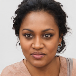 Joyful black young-adult female with long  brown hair and brown eyes