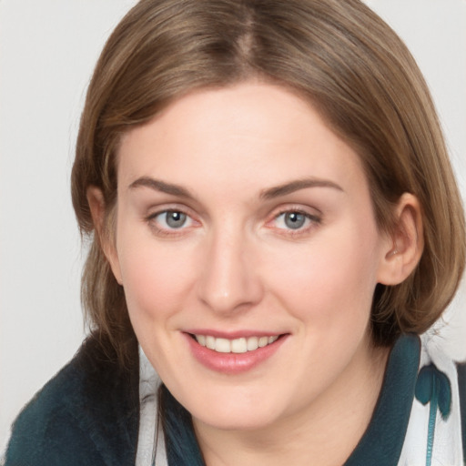 Joyful white young-adult female with medium  brown hair and grey eyes