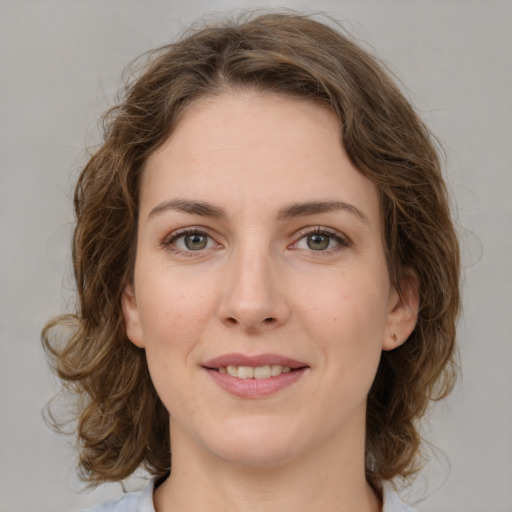 Joyful white young-adult female with medium  brown hair and green eyes