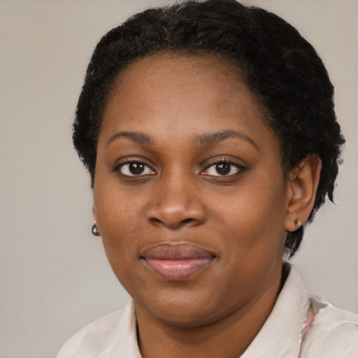 Joyful black young-adult female with short  brown hair and brown eyes
