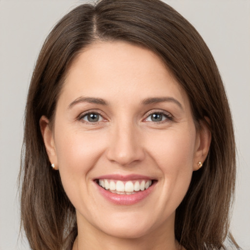 Joyful white young-adult female with medium  brown hair and grey eyes