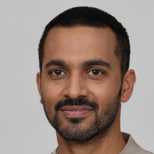 Joyful black young-adult male with short  black hair and brown eyes