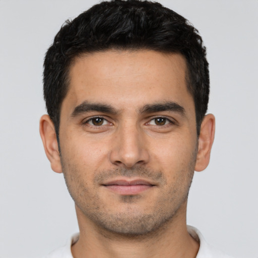 Joyful latino young-adult male with short  brown hair and brown eyes