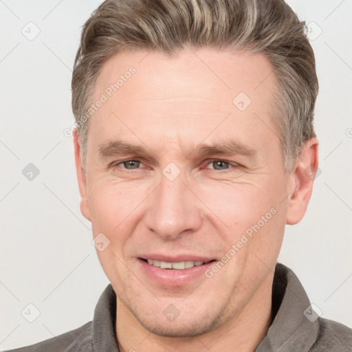 Joyful white adult male with short  brown hair and grey eyes