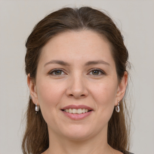 Joyful white young-adult female with medium  brown hair and grey eyes