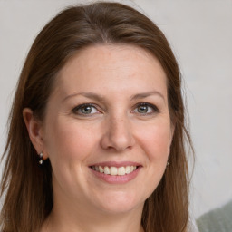 Joyful white young-adult female with long  brown hair and grey eyes