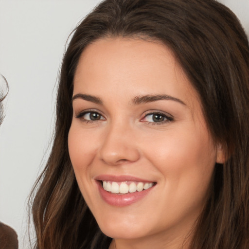 Joyful white young-adult female with long  brown hair and brown eyes