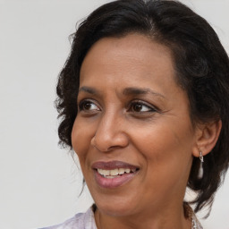 Joyful black adult female with medium  brown hair and brown eyes