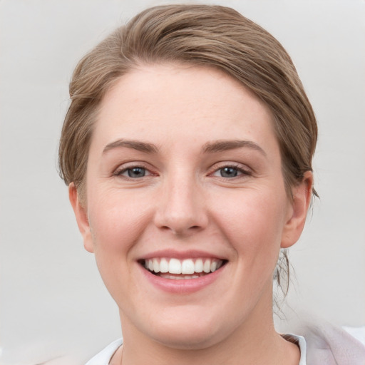 Joyful white young-adult female with short  brown hair and grey eyes