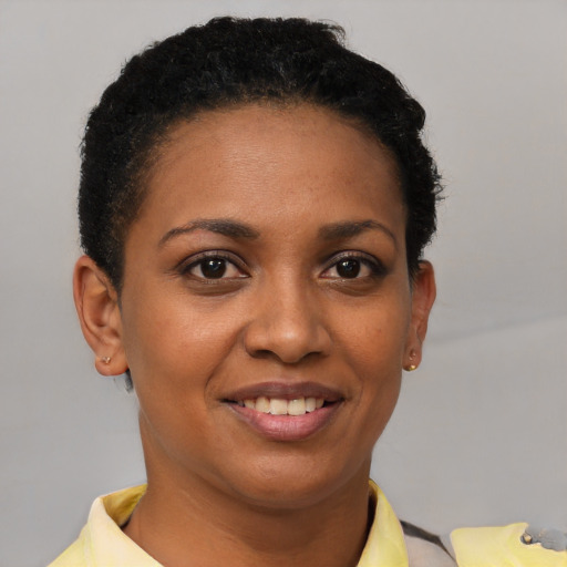 Joyful black young-adult female with short  brown hair and brown eyes