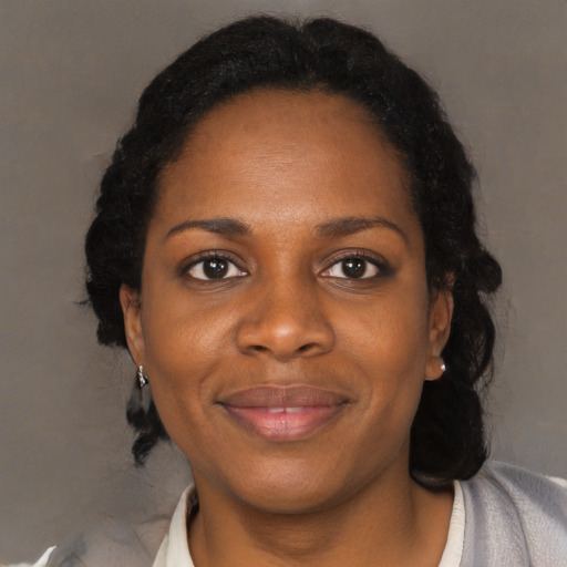 Joyful black adult female with medium  black hair and brown eyes