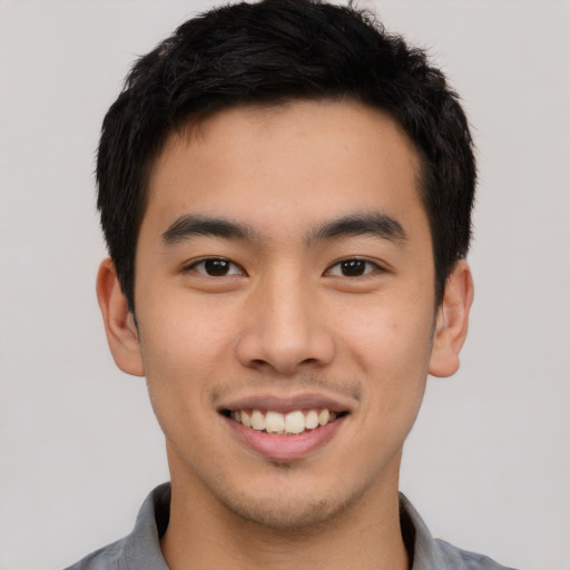 Joyful asian young-adult male with short  black hair and brown eyes