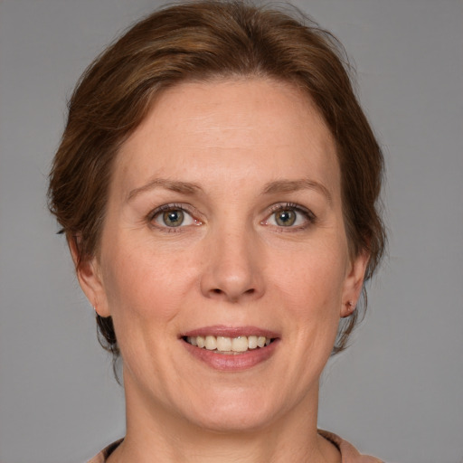 Joyful white adult female with medium  brown hair and grey eyes