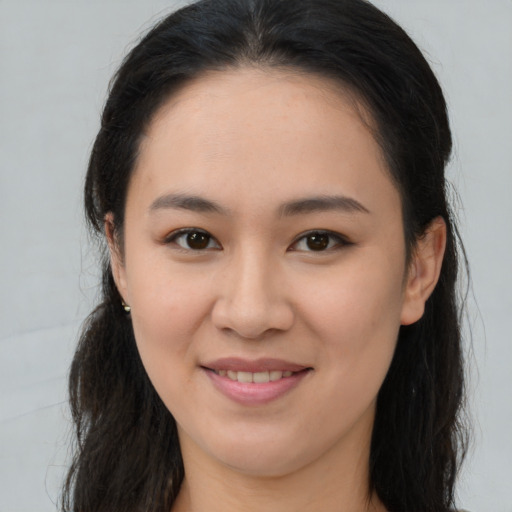 Joyful asian young-adult female with long  brown hair and brown eyes