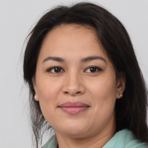 Joyful latino adult female with medium  brown hair and brown eyes