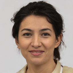 Joyful latino adult female with medium  brown hair and brown eyes