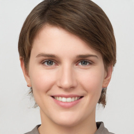 Joyful white young-adult female with short  brown hair and grey eyes