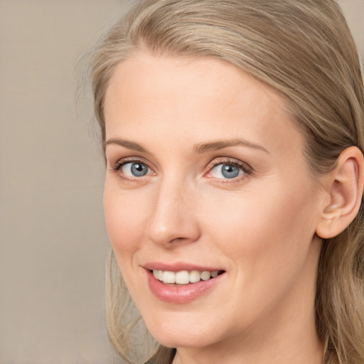 Joyful white young-adult female with medium  brown hair and blue eyes