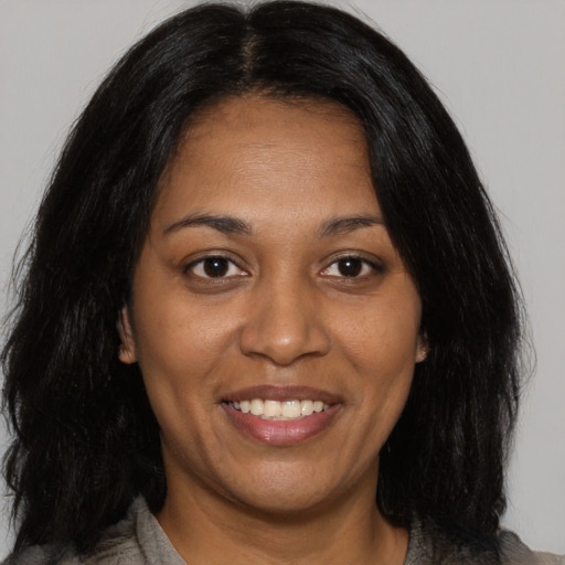 Joyful black adult female with medium  brown hair and brown eyes