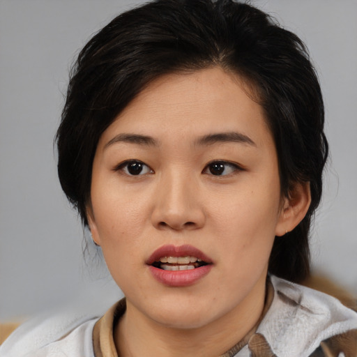 Joyful asian young-adult female with medium  black hair and brown eyes