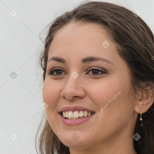 Joyful white young-adult female with long  brown hair and brown eyes