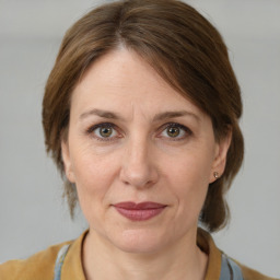 Joyful white adult female with medium  brown hair and grey eyes