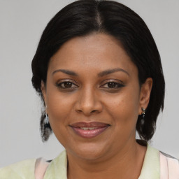 Joyful black adult female with medium  brown hair and brown eyes