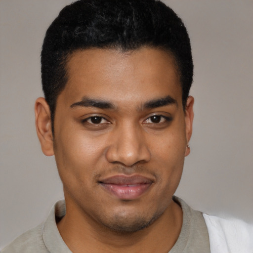 Joyful latino young-adult male with short  black hair and brown eyes