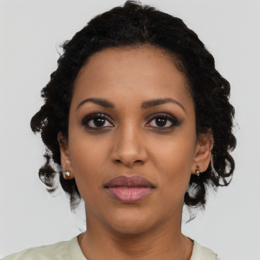 Joyful black young-adult female with medium  black hair and brown eyes