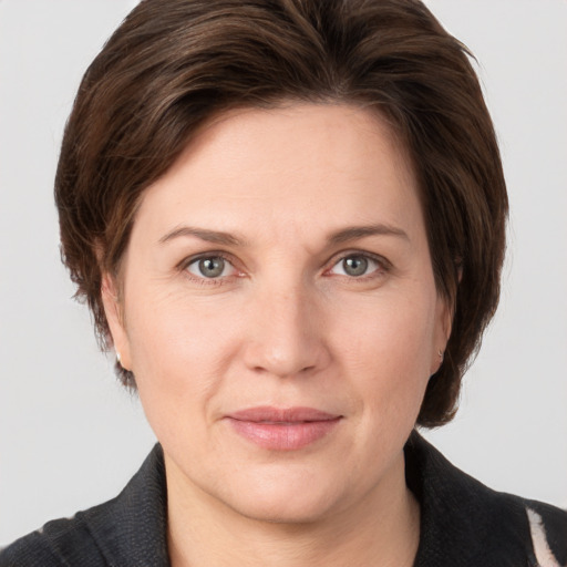 Joyful white adult female with medium  brown hair and grey eyes