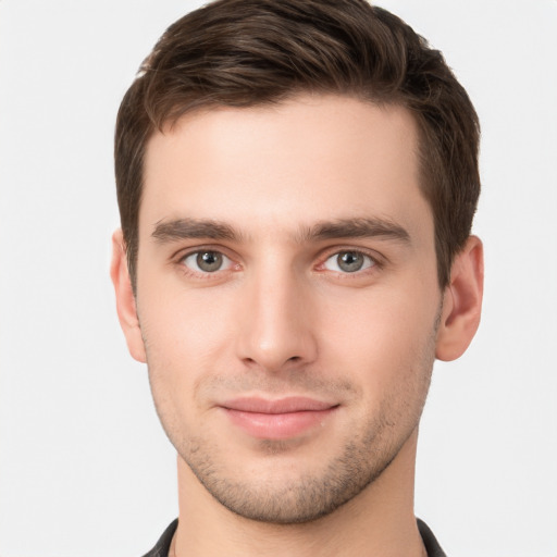 Joyful white young-adult male with short  brown hair and grey eyes