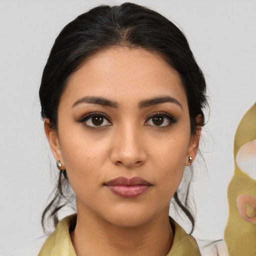 Joyful latino young-adult female with medium  brown hair and brown eyes