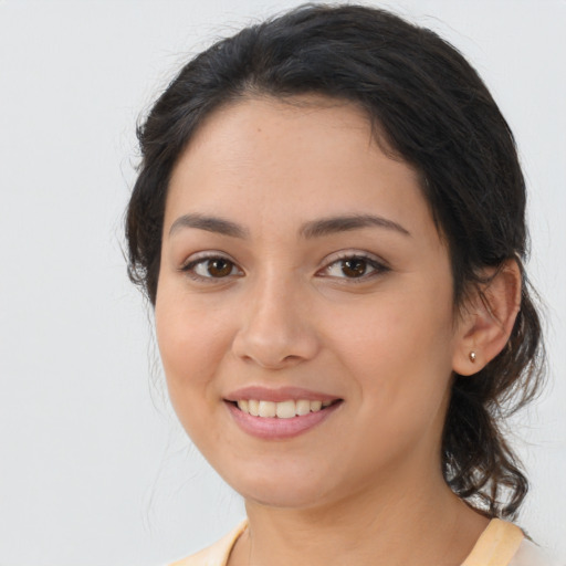 Joyful latino young-adult female with long  brown hair and brown eyes