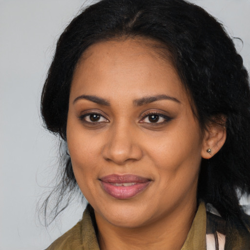 Joyful black adult female with long  black hair and brown eyes