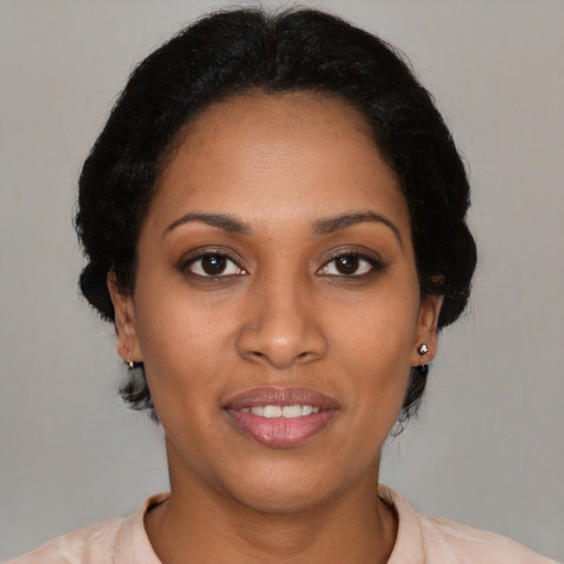 Joyful black young-adult female with short  black hair and brown eyes