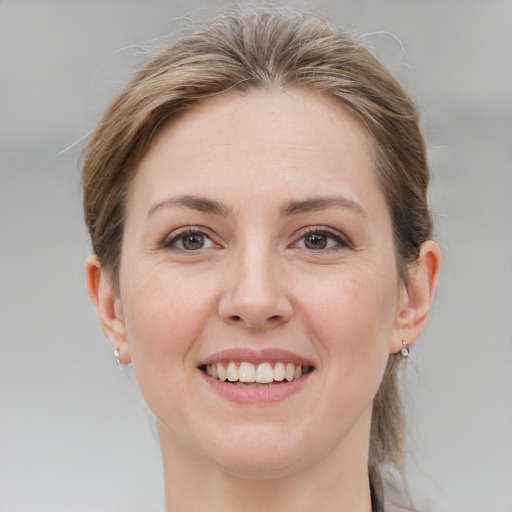 Joyful white young-adult female with medium  brown hair and grey eyes