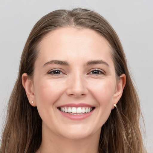 Joyful white young-adult female with long  brown hair and grey eyes