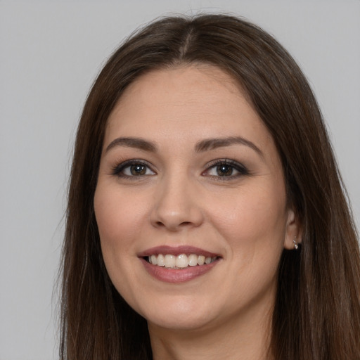 Joyful white young-adult female with long  brown hair and brown eyes