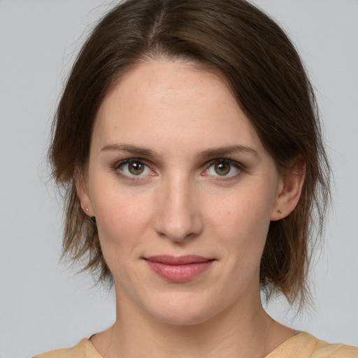 Joyful white young-adult female with medium  brown hair and green eyes