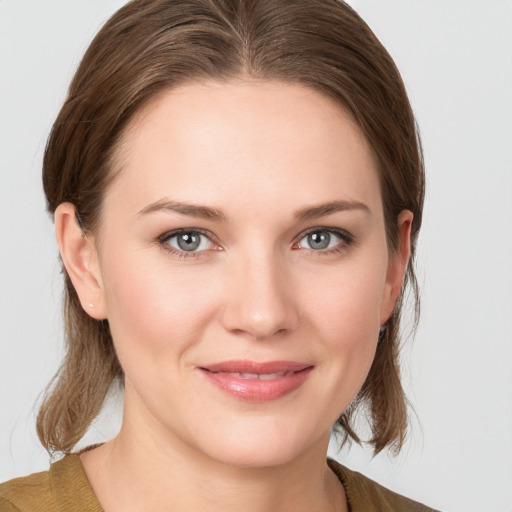 Joyful white young-adult female with medium  brown hair and grey eyes