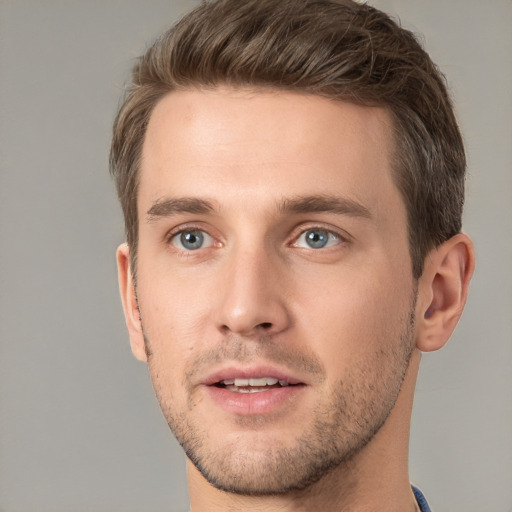 Joyful white young-adult male with short  brown hair and grey eyes