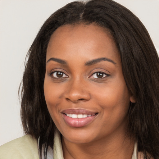 Joyful black young-adult female with long  brown hair and brown eyes