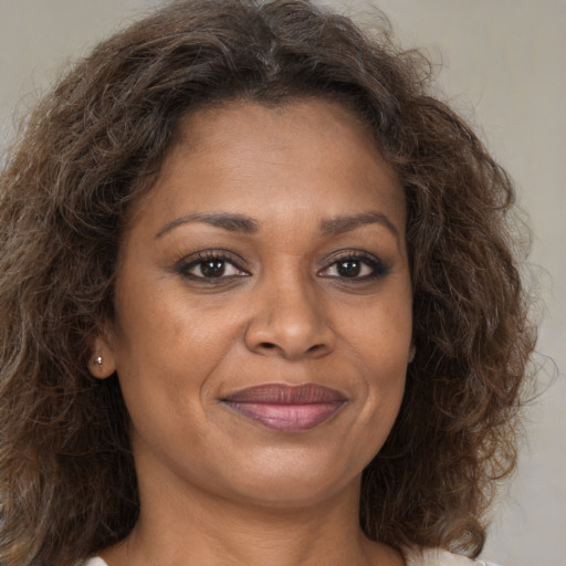 Joyful black adult female with long  brown hair and brown eyes