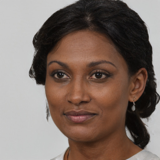Joyful black adult female with medium  brown hair and brown eyes