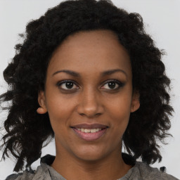 Joyful black young-adult female with medium  brown hair and brown eyes