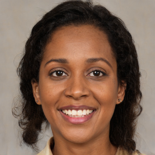 Joyful black young-adult female with medium  brown hair and brown eyes