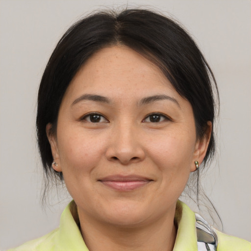 Joyful asian adult female with medium  brown hair and brown eyes