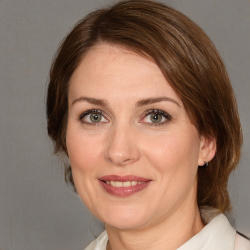 Joyful white adult female with medium  brown hair and brown eyes