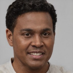 Joyful latino young-adult male with short  brown hair and brown eyes